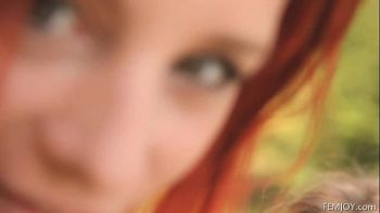 Рыженькая девушка любуется своим загорелым телом в зеркале